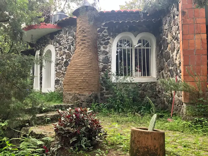 The stone facade of a building with arched windows and a terracotta roof.
